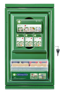 Green first aid cabinet with compartments containing bandages and wound care products. Labels include "4-in-1 Mini" and "Salvequick," with illustrated instructions for use and a key hanging on the side.