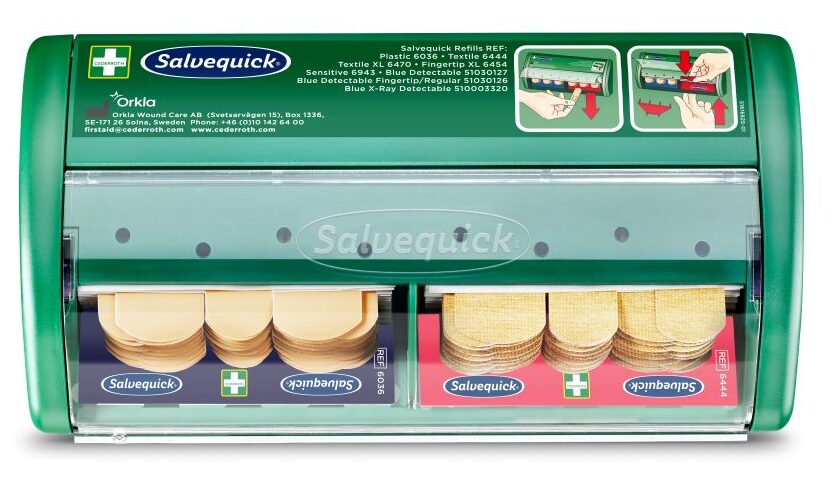 Distributeur vert de pansements Salvequick avec deux compartiments contenant des pansements textiles et plastiques. Instructions illustrées sur le dessus pour le remplacement des recharges.